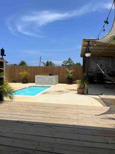 a backyard with a swimming pool and a wooden fence at El Camper RV with pool. in Aguadilla