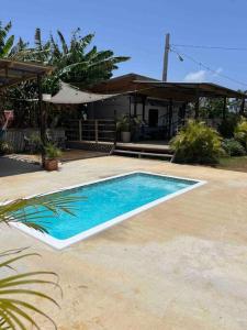 a swimming pool in front of a house at El Camper RV with pool. in Aguadilla