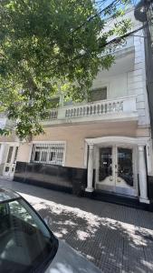 un edificio blanco con una puerta en una calle en Apartamento Alberdi 1634 en Buenos Aires