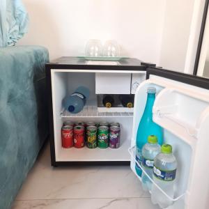 een open koelkast gevuld met drankjes en frisdrank bij B&B Pousada Swiss Residence in Aquiraz