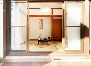 Habitación con puerta de cristal y mesa. en TOKYO/Shinjuku & Shibuya 10mins/5mins walk to subway stiaon/Kichijoji 15mins/Shimokitazawa 5mins/Louis House, en Tokio
