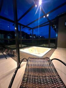 a bench on a balcony with a bath tub at Pousada Atalaia Village in Campos do Jordão