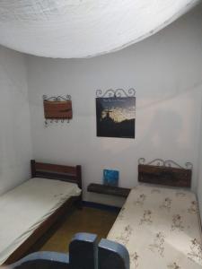a room with two beds and a picture on the wall at CASA COLONIAL C/ GRANDE QUINTAL.CENTRO HISTÓRICO in Paracatu
