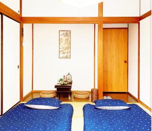 two blue beds in a room with a cross on the wall at TOKYO/Shinjuku & Shibuya 10mins/5mins walk to subway stiaon/Kichijoji 15mins/Shimokitazawa 5mins/Louis House in Tokyo