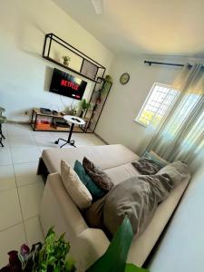 a living room with a couch and a tv at Apartamento 3/4 ótima localização in Aracaju