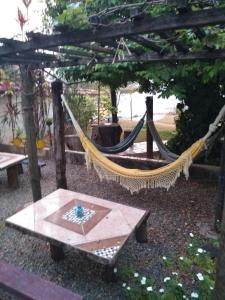 uma rede de descanso num jardim com uma mesa em CASA COLONIAL C/ GRANDE QUINTAL.CENTRO HISTÓRICO em Paracatu