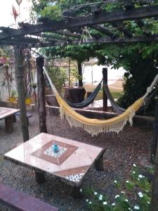 een hangmat in een tuin met een tafel bij CASA COLONIAL C/ GRANDE QUINTAL.CENTRO HISTÓRICO in Paracatu