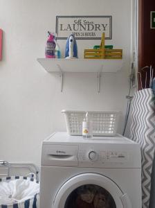 a washing machine in a laundry room with a shelf at Alojamento local Os Maias in Mirandela