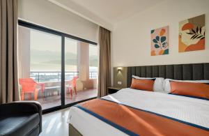 a bedroom with a bed and a balcony with a table at THE LOFT HOTEL By BRATUS in Aqaba