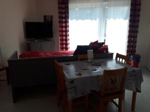 - une salle à manger avec une table, des chaises et un lit dans l'établissement Le Cocon d'Alsace, à Folgensbourg