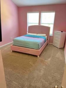 ein rosafarbenes Schlafzimmer mit einem Bett und einer Kommode in der Unterkunft Townhome Baptist South St JohnsTownCenter Beach in Jacksonville