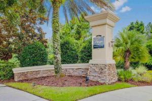 a sign in a brick wall with a palm tree at Townhome Baptist South St JohnsTownCenter Beach in Jacksonville