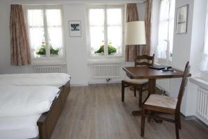 - une chambre avec 2 lits, un bureau et une table dans l'établissement Gasthof Löwen, à Melchnau