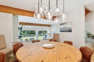 uma sala de jantar com uma mesa de madeira e cadeiras em Topnotch 329E em Stowe