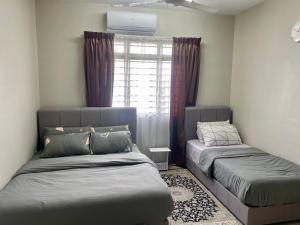 een slaapkamer met 2 bedden en een raam bij Omma Homestay Putrajaya, Presint 17 in Putrajaya