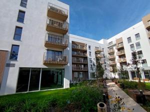 an apartment building with balconies and a yard at Domitys Calandra in Villepinte