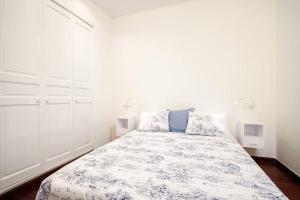 Schlafzimmer mit einem Bett mit einer blauen und weißen Bettdecke in der Unterkunft FANTASTIC apartment in Barcelona in Barcelona
