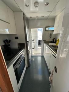 a kitchen with white cabinets and a sink at YACHT 20Metros in Barcelona