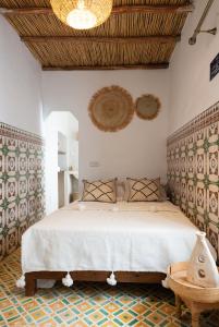 a bedroom with a large bed with a wooden ceiling at RIAD MAJWRIL in Marrakesh
