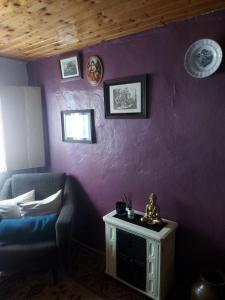 a room with a purple wall with a chair and a table at o Roxo in Castelo de Vide