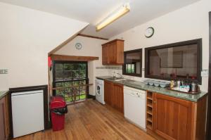 a large kitchen with wooden cabinets and a counter top at Makeney Chapel in Duffield