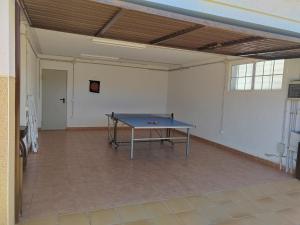 una mesa de ping pong en el medio de una habitación en Villa Genís, en Calafell