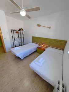 1 dormitorio con 2 camas y ventilador de techo en Villa Genís, en Calafell