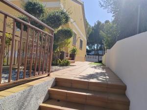 una escalera que conduce a un edificio con una valla en Villa Genís, en Calafell