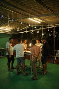 a group of people standing around a table in a room at Willow Creek in Wayanad