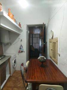 a small kitchen with a wooden table in a room at o Roxo in Castelo de Vide
