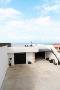 biały dom z widokiem na ocean w obiekcie Refúgio do Mar w mieście Aguçadoura