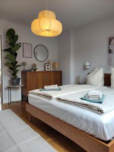 1 dormitorio con 1 cama blanca grande con lámpara en WÄLDER: Quartier Birkle in Titisee, en Titisee-Neustadt