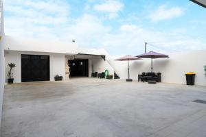 a white building with two umbrellas and a patio at Refúgio do Mar in Aguçadoura