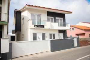 a white house with a white garage door at Refúgio do Mar in Aguçadoura