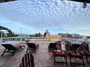 a patio with chairs and tables on a balcony at Hostal Gardner in Puerto Ayora