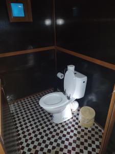 a bathroom with a white toilet in a black wall at Merzouga Luxury Traditional Camp in Merzouga