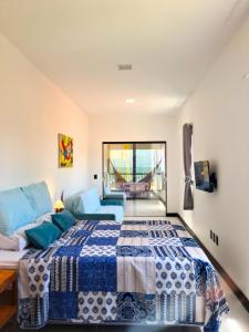 a bedroom with a bed with a blue comforter at B&B Pousada Swiss Residence in Aquiraz