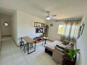 ein Wohnzimmer mit einem Sofa und einem Tisch in der Unterkunft Apartamento 3/4 ótima localização in Aracaju