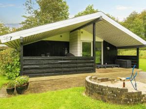 a building with a roof with a patio at 6 person holiday home in Fårvang in Fårvang