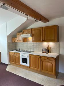 uma cozinha com armários de madeira e um forno com placa de fogão em Appartement Stahlhammer em Flachau