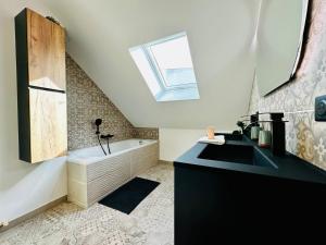 uma casa de banho com um lavatório preto e uma banheira em T5 grand confort hyper centre em Tours