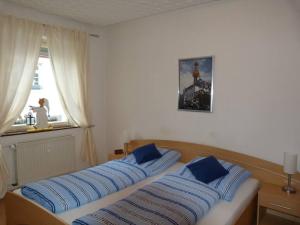 een slaapkamer met een bed met blauwe kussens en een raam bij Ferienwohnung Marbach-Zentrum in Marbach am Neckar