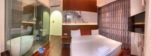 małą sypialnię z łóżkiem i wanną w obiekcie FUN HOTEL w Ho Chi Minh