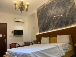 sypialnia z łóżkiem i dużą marmurową ścianą w obiekcie FUN HOTEL w Ho Chi Minh