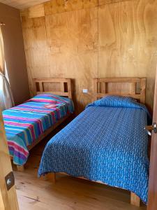 2 Betten nebeneinander in einem Zimmer in der Unterkunft Cabañas Guanaqueros Arriendo Diario in Guanaqueros