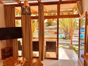 - un salon avec une grande porte en verre donnant sur une piscine dans l'établissement Sababa Resort, à San Pedro de la Laguna
