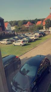 eine Gruppe von Autos, die auf einem Parkplatz geparkt sind in der Unterkunft BALTIC VIBES APARTAMENT in Kołobrzeg