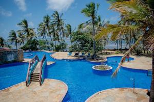 a resort with a blue pool with palm trees at Lamera in Mombasa