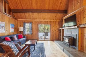 a living room with a couch and a fireplace at Evergreen Chalet in Stowe