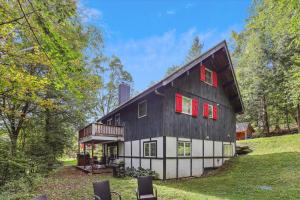 a black and white barn with red windows at Evergreen Chalet in Stowe